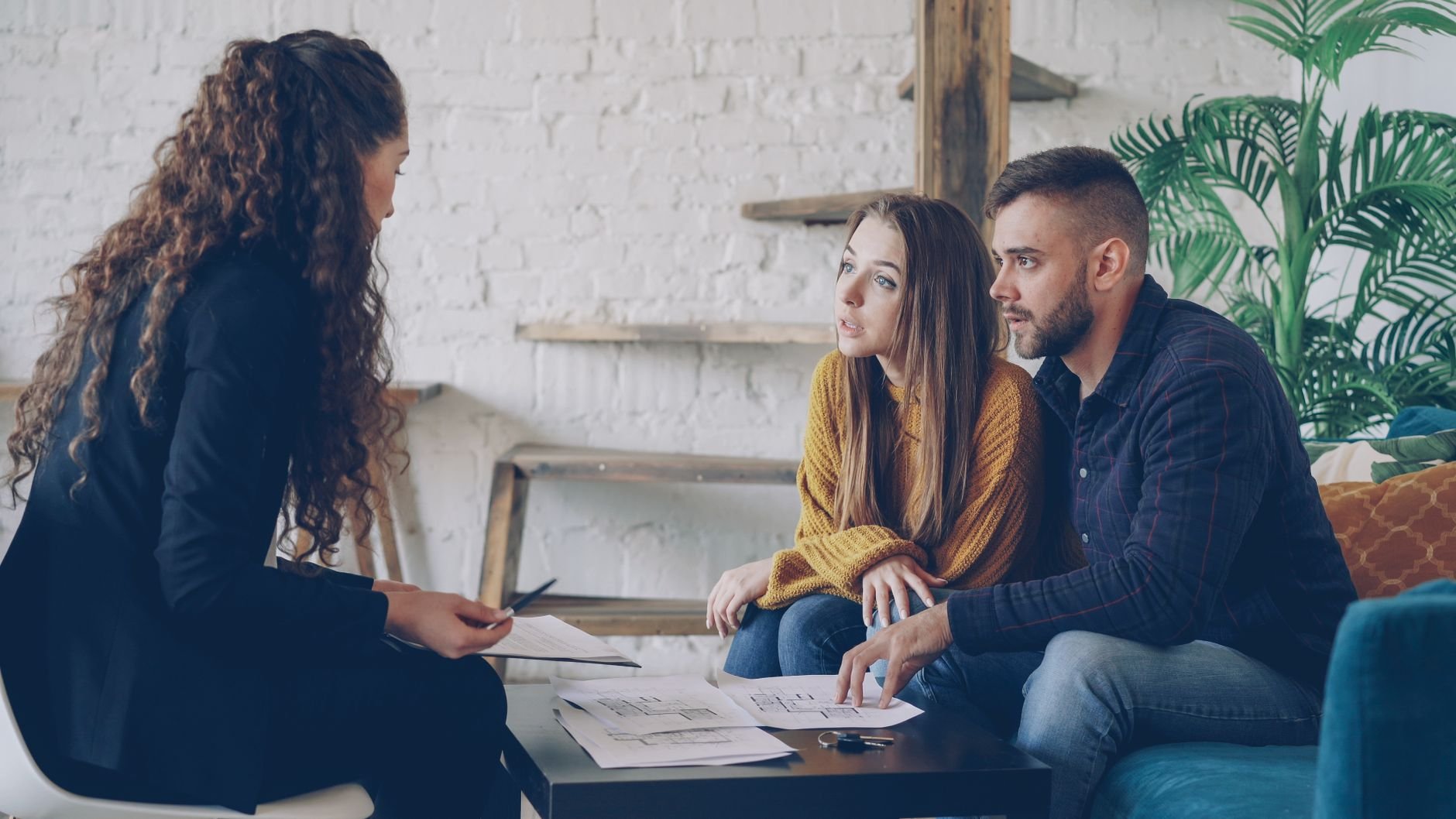 Couple in conversation with a trusted financial advisor in a warm office setting